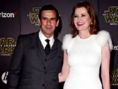  Reza Jarrahy is on a black suit whereas, Geena Davis is wearing a white dress.